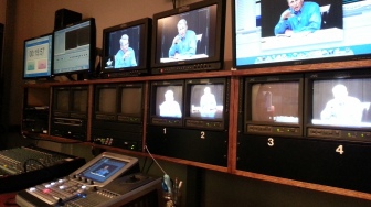 many screens and computer equipment in a TV control room