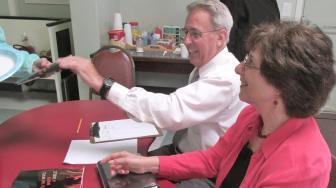 man and woman sitting at a table for book signing